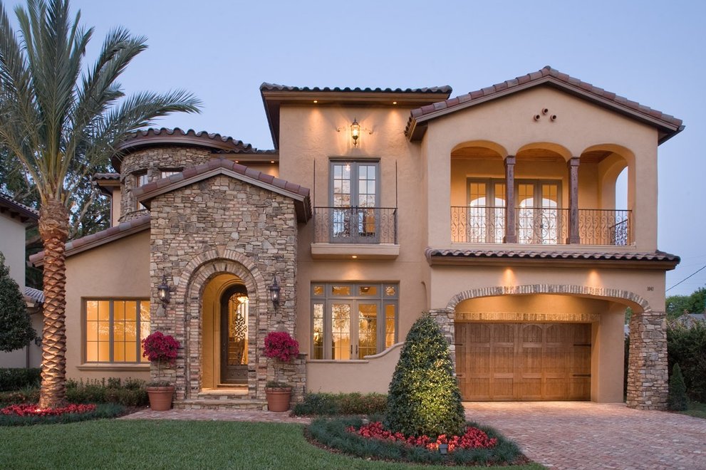 Spanish-style florida House taken at dusk with the lights on.